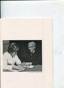 Woman teaching Braille to an elderly man