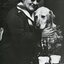 A blind woman pats a guide dog dressed in tinsel
