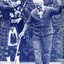 Elderly man with white cane dancing whilst bagpiper play in the background