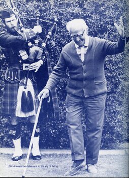 Elderly man with white cane dancing whilst bagpiper play in the background