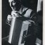Elderly man holds a piano accordian