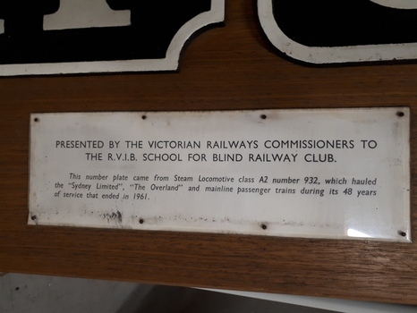 Cast iron train numbers mounted on wood with presentation plaque