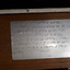 Braille metal plate on wooden sign