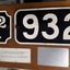 Cast iron train numbers mounted on wood