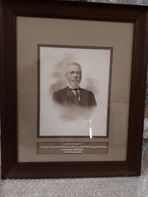 Framed photograph with inscription below.