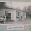 Three people standing around a weatherboard cottage