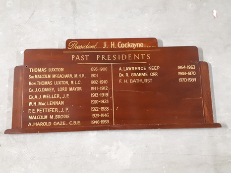 Brown wooden board with gold lettering