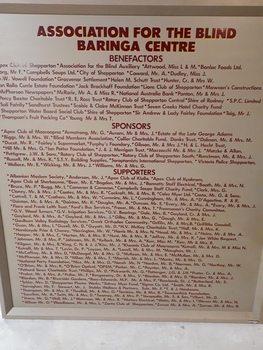 Blonde wooden board with maroon text