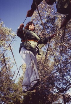 Woman crossing a rope bridge in bushland