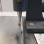 Metal sheet with ridges to align items above a punch activated by a lever pushed downwards