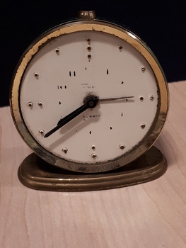 Gold clock with white clock face and black hands
