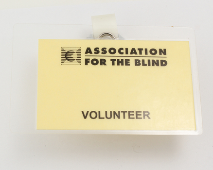 Large badge with yellow background and black writing