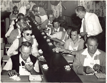 Two rows of men on an assembly line