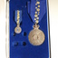Open case with blue inlay and blue cloth with wattle on them attached to medals