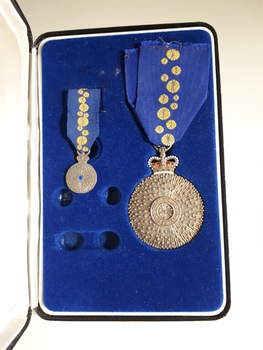 Open case with blue inlay and blue cloth with wattle on them attached to medals