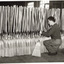 Man stacking finished millet head brooms
