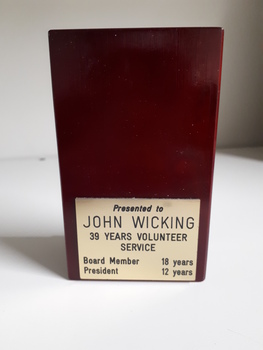 Rear of wooden maroon block with name plate on back