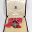 Medal with four points hangs from ribbon inside black box
