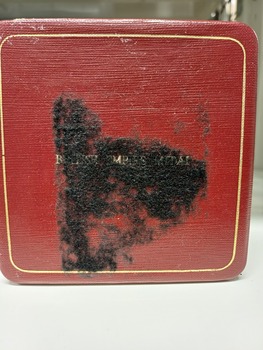 Red box with black material covering 'British Empire Medal' lettering