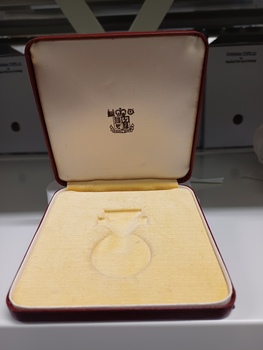Velvet insert for medal and 'Royal Mint' coat of arms printed on lid.