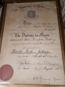 Framed diploma with black writing and red seal
