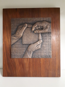 Two hands holding grid with third hand putting missing piece back.