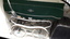 Side view of green pram with white lining and chrome detail