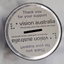 Metal tin with gap in lid and sticker on top