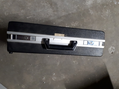 Silver case and keyboard with red, tan and black buttons inside black briefcase