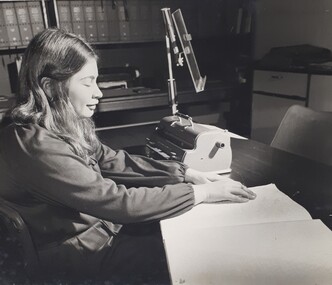 Woman reading Braille next to a Perkins