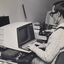 Man wearing a Sonic Guide types on a computer with an Opticon beside him