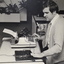 Man sits in front of typewriter with device attached, places his hand on a Opticon