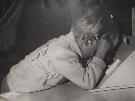 Blonde haired young boy holds the handle whilst peering into the box