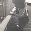 Young boy holding on to railing as he moves downstairs