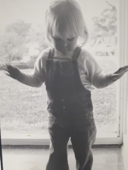 Young boy standing in front of large window
