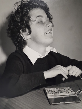Boy threading pieces on to a cord