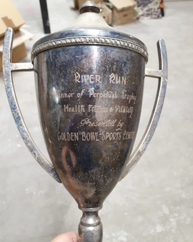 Tarnished silver cup with lid and with two holders either side and engraving.