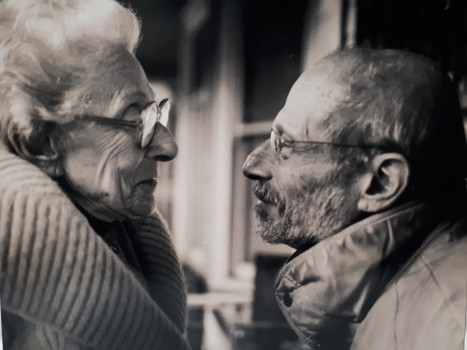 An elderly female and older man face each other.