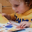 A young child looks at a brightly coloured book