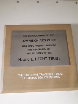 Metal plaque attached to larger board with writing