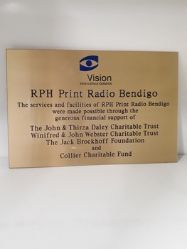 Golden coloured plate with inscription and Vision Australia Foundation Eye logo