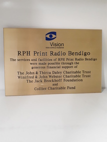 Golden coloured plate with inscription and Vision Australia Foundation Eye logo