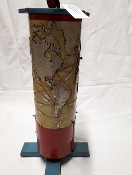 Metal cylindrical map with tactile markers showing the Americas