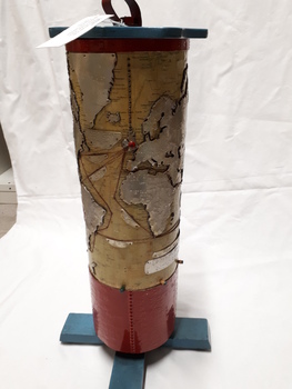 Metal cylindrical map with tactile markers showing Atlantic Ocean