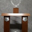 Wooden rectangle topped with a plastic wreath and tarnished silver plates inscribed with winner names