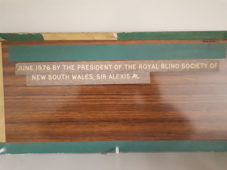 Laminate board with woodgrain finish and etched white lettering - on rear of board 
