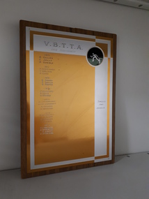 Laminate board with golden and silver coloured engraved sheet attached