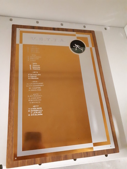 Laminate board with golden and silver coloured engraved sheet attached