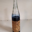 Glass bottle with ink and paper label "Made by the Blind"