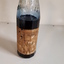 Glass bottle with ink and paper label "Made by the Blind"